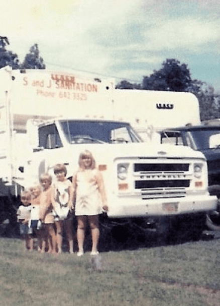 old picture of kids in front of garbage truck